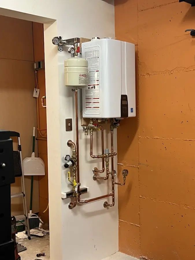 Plumbing technician inspecting water heater connections in Cedar Grove